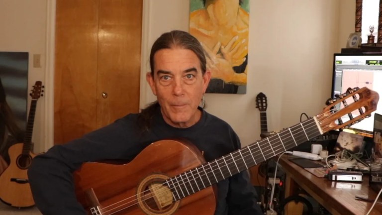 Michael Chapdelaine seated holding classical guitar