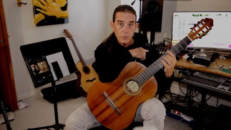 guitarist michael chapdelaine seated in his home studio holding a nylon-string guitar