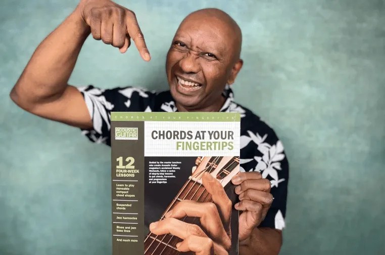 Ron Jackson holding a copy of 'Chords at Your Fingertips'