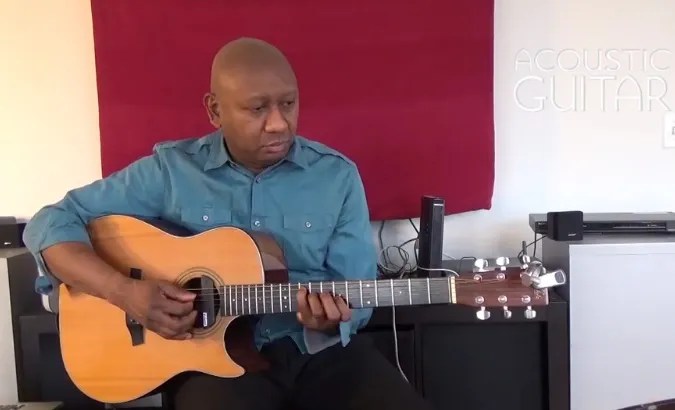 Ron Jackson, seated and holding an acoustic guitar, performs the examples from this lesson on accompaniment