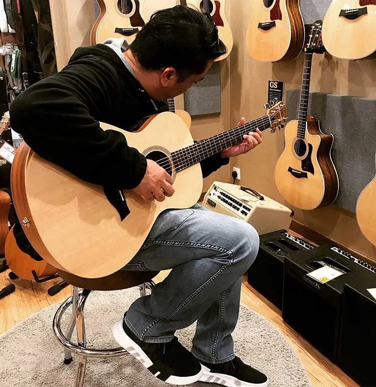 playing acoustic guitar in a guitar shop