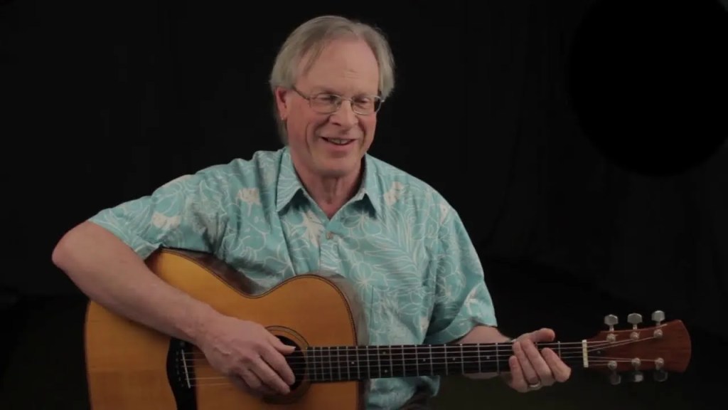 Danny Carnahan seated with acoustic guitar