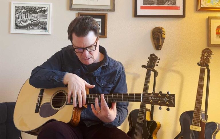 Sean McGowan playing harmonics on an acoustic guitar