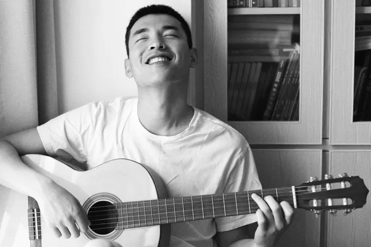 smiling man with acoustic guitar