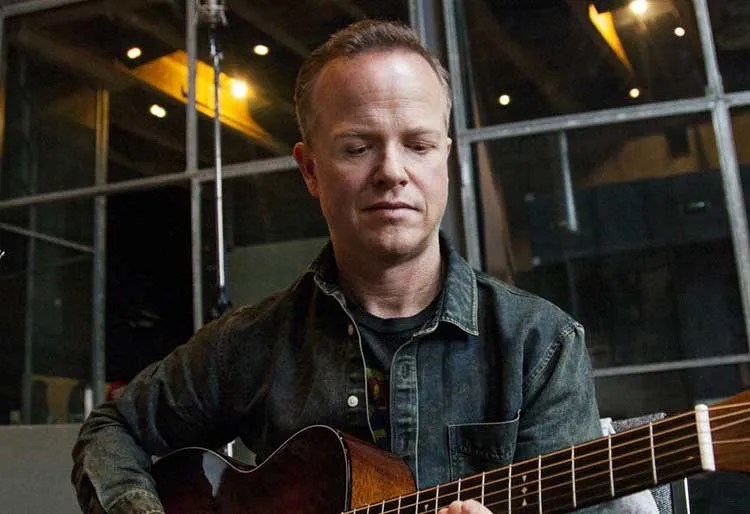 Steve Dawson seated with acoustic guitar