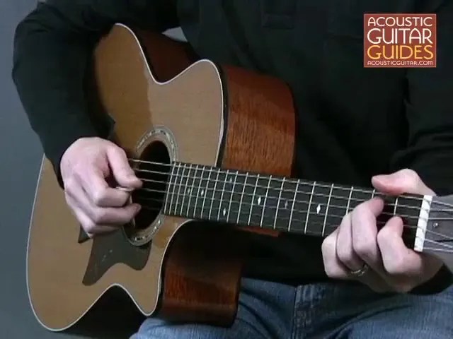 closeup of hands playing an acoustic guitar