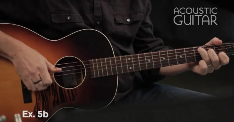 closeup of a guitarist playing an acoustic guitar