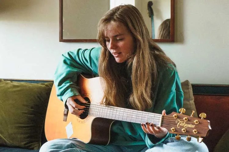 woman playing acoustic guitar and singing